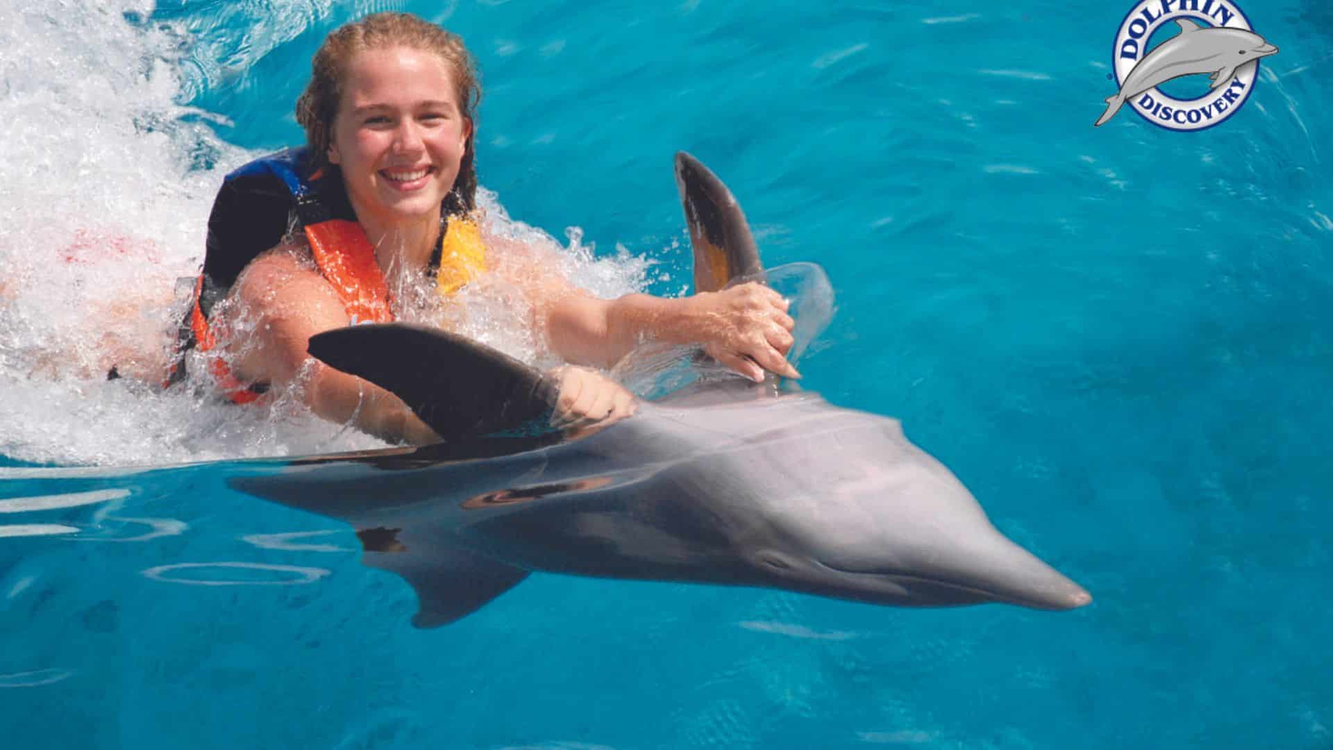 Delfín realizando un dorsal tow: Delfín arrastrando a una persona con su aleta dorsal.