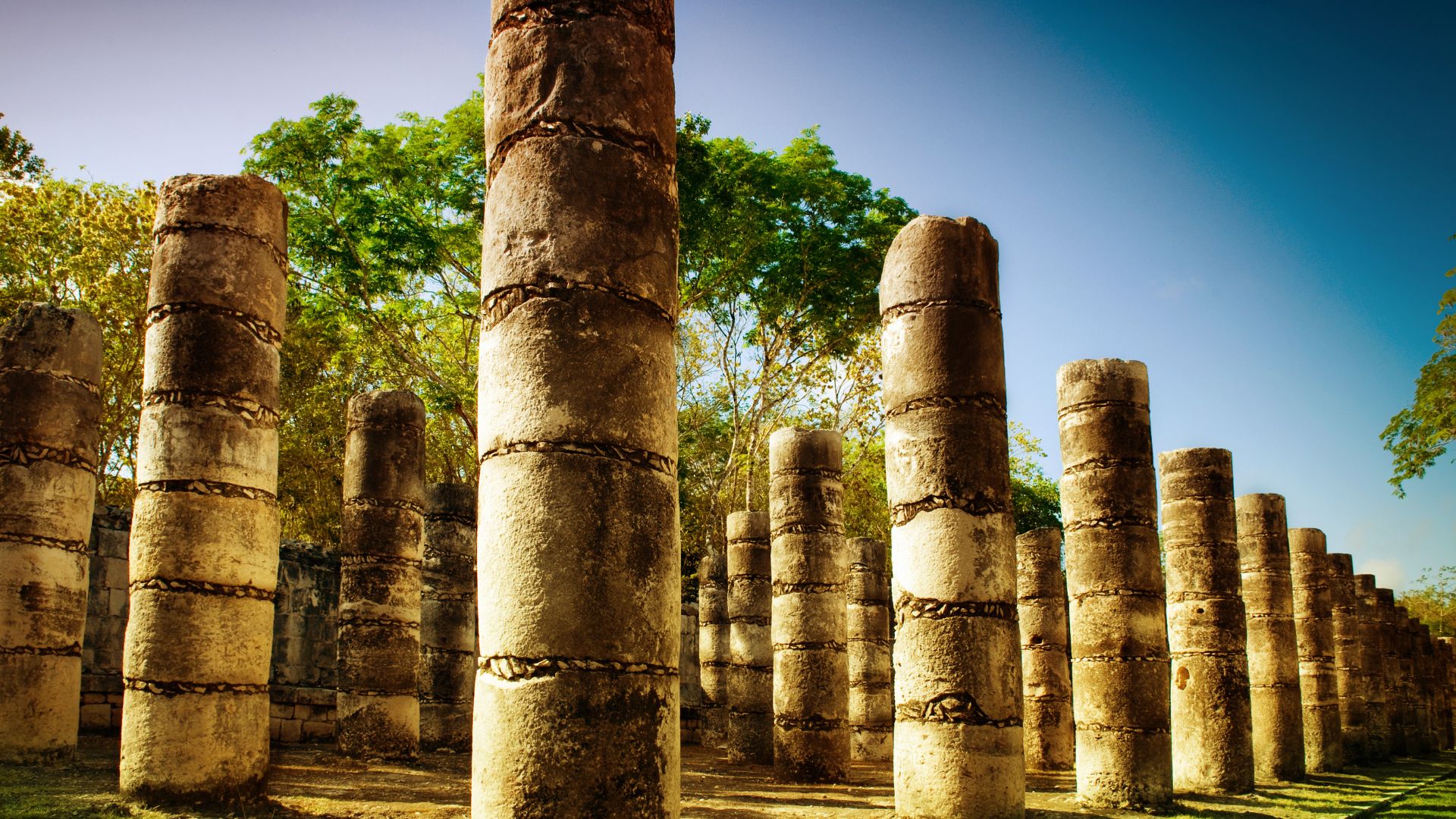 Guía turístico mostrando la arquitectura del Templo de los Guerreros en Chichén Itzá.